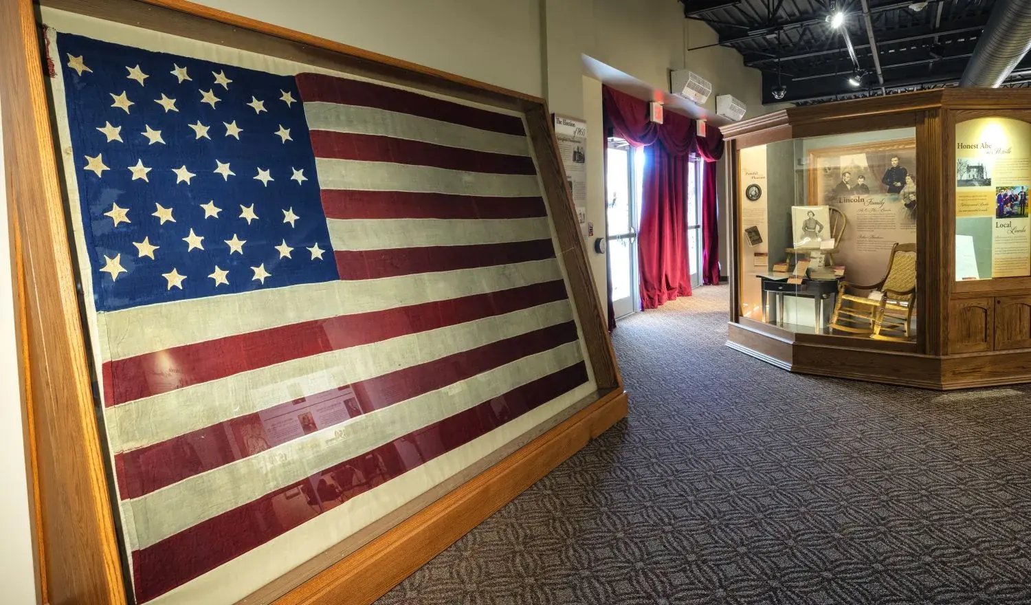 The first-floor gallery with a large historic American flag mounted above display cases.